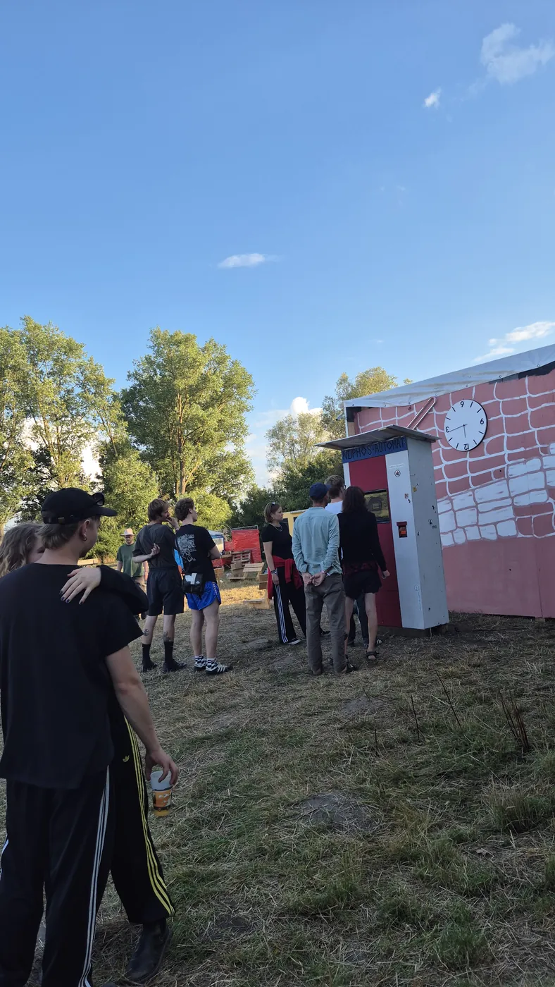 Warteschlange von Gästen vor dem Automaten auf einem Festivalgelände