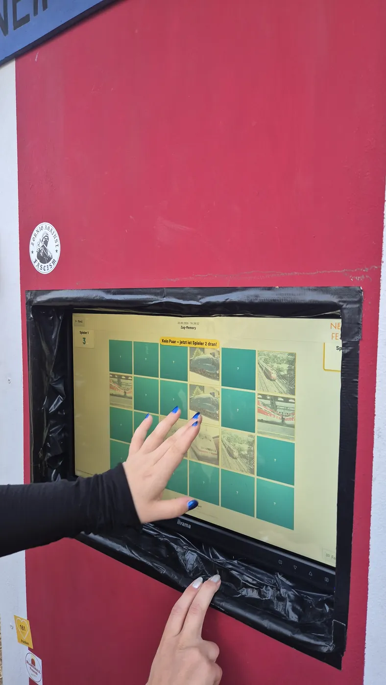Hand bedient das Minispiel auf dem Touchscreen des Automaten